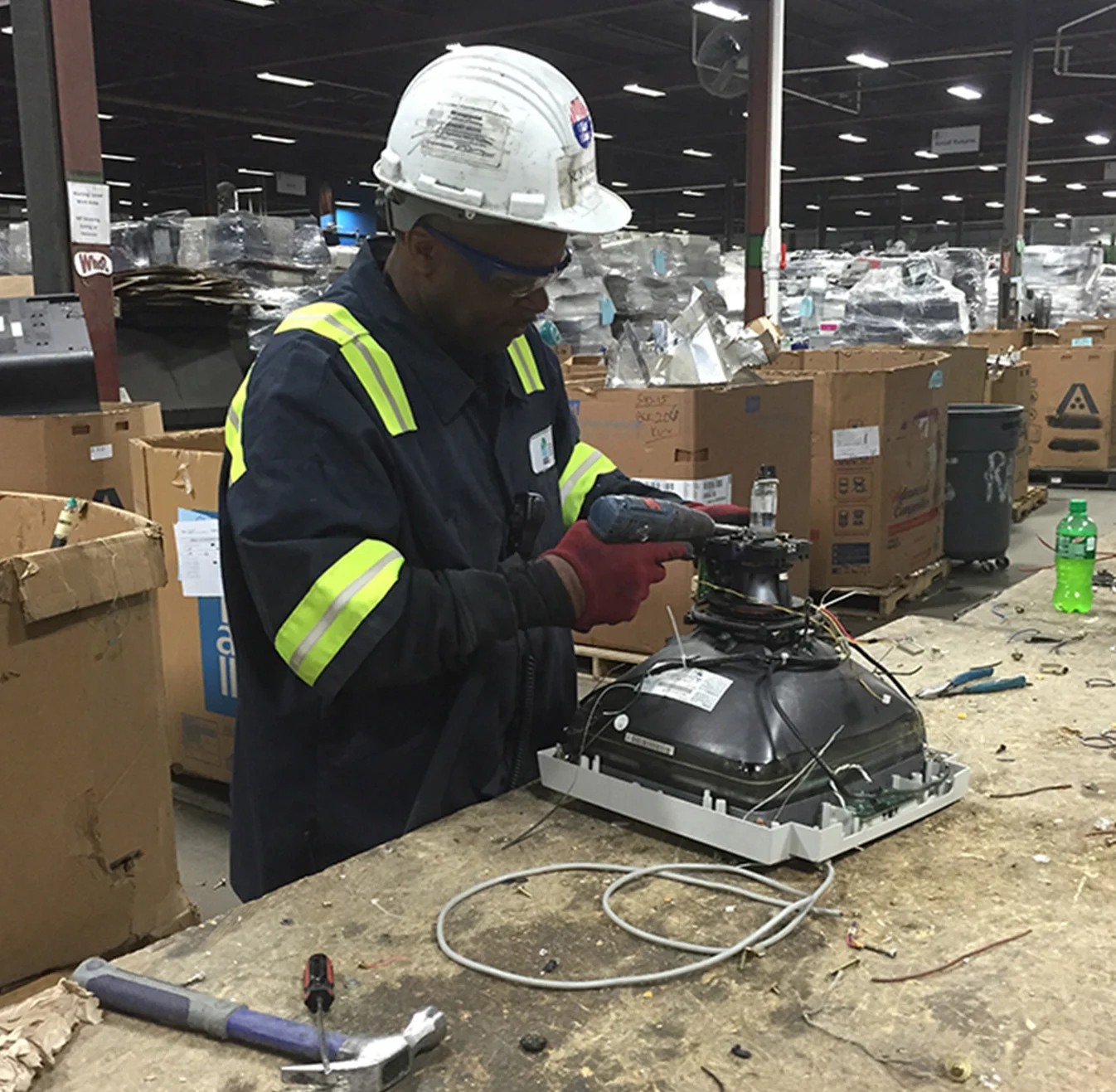 Man working with a machine wearing a hard hat