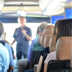 Person speaking to a bus of people