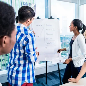 People looking at a list on a whiteboard