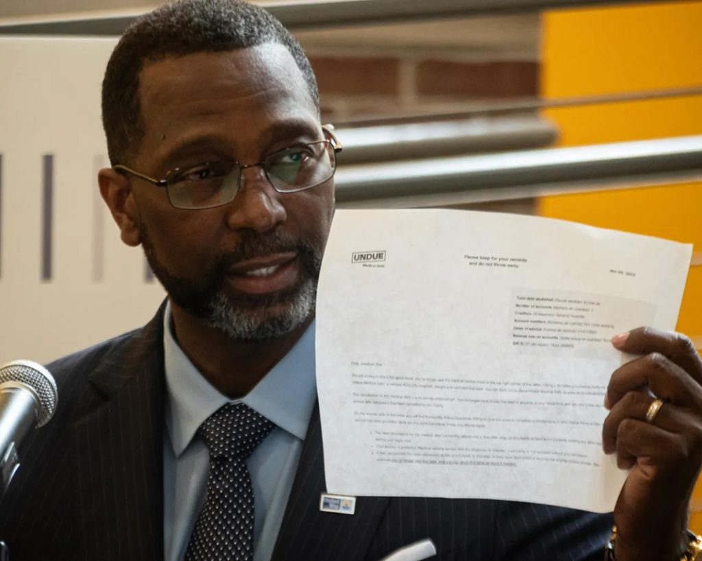Black man holding up white piece of paper