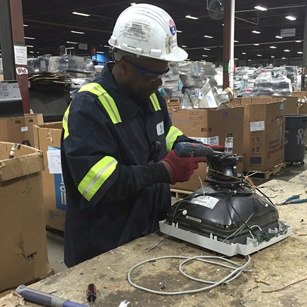 Man working on something electric that is being recycled