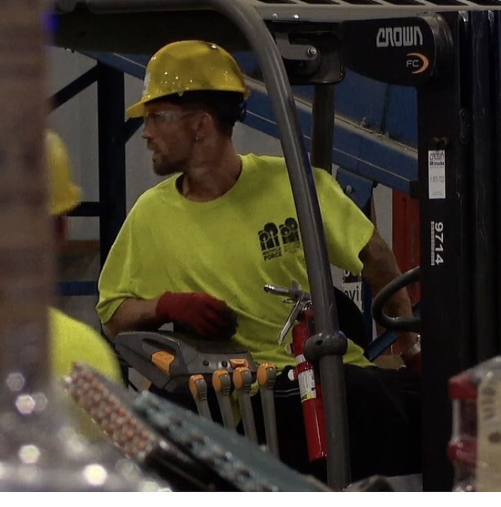Man in construction Hat with bright shirt working machinery