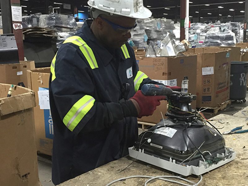 Man working on something electric that is being recycled